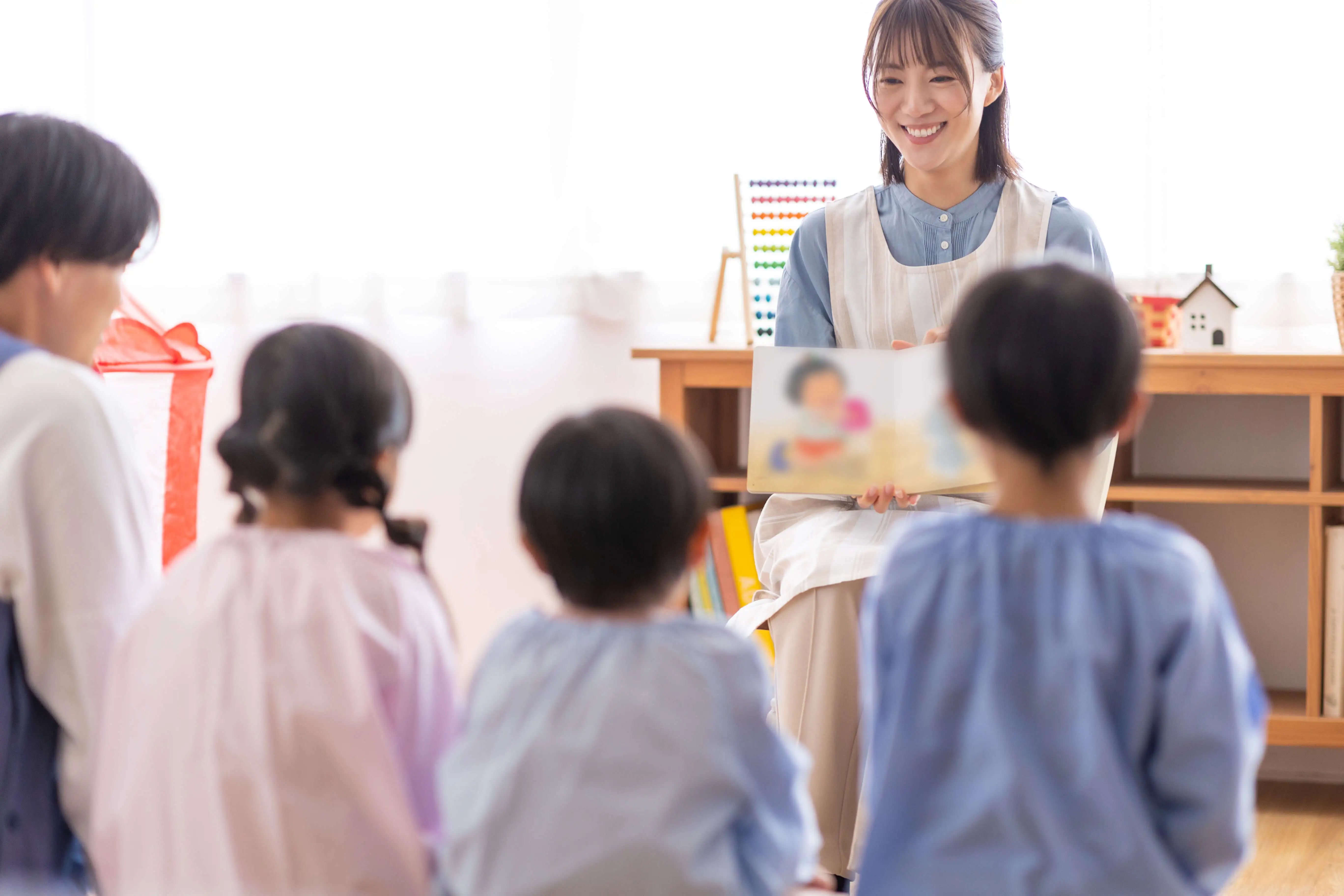 園児たちが絵本の読み聞かせを見る様子